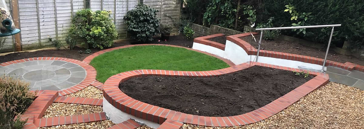 Hard landscaping with curved lawn, patio, bedding and steps 