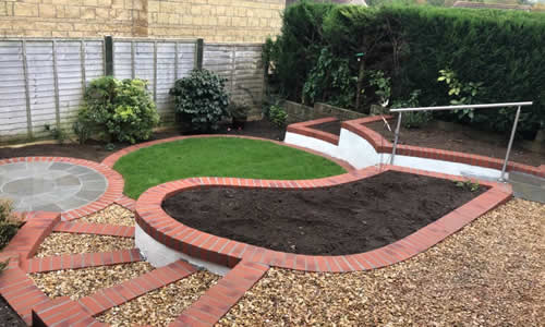 Hard landscaping with curved lawn, patio, bedding and steps